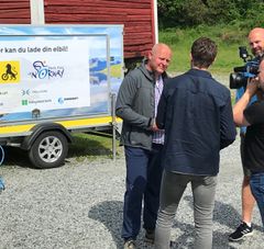 Administrerende direktør Stig Skjøstad i NAF (t.v) og generalsekretær Dag Terje Solvang i DNT (t.h) er fornøyd med de mobile ladestasjonene fra Arctic Race of Norway. Her intervjues de av TV2. Foto: ARN