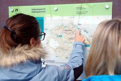 To besøkende studerer kartet over Hallingskarvet nasjonalpark før turen. Foto: Trond Erik Buttingsrud.