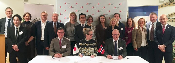 Rektorene Dag Rune Olsen (UiB) og Gunnar Bowim (NTNU) på hver sin side av Anita Krohn Traaseth (Innovasjon Norge). Representanter fra den japanske ambassaden, departementene og Innovasjon Norge i bakgrunnen. (Foto: Innovasjon Norge)