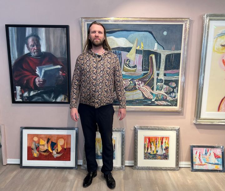 Aune Sand med kunstverk fra broren, faren og samboeren i pop up-utstillingen i Hamar sentrum. Foto: Visit Mjøsa