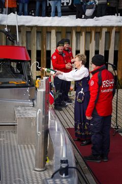 Gudmor Fredhild Sæthre gir støttefartøyet en sjampanjedusj under dåpen. (Foto: Arja Grimstad Ones / Redningsselskapet)