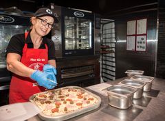 PIZZA-SUKSESS. Katergorisjef mat, Trude Marchmann-Jensen, tilbereder en Peppes On The Go-pizza. Nasjonalt har Circle K Norge nå solgt 1,5 millioner pizzaenheter. Foto: Johnny Syversen
