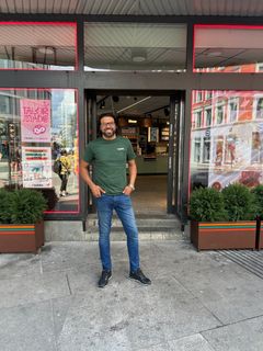 Kjøpmann Mohsin Munir foran den nyåpnede butikken.