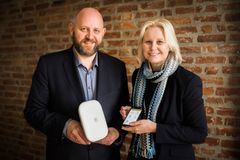 Administrerende direktør Espen Hansen og styreleder Bente Sollid Storehaug i Hitch viser frem Hitch hussentral og app. Dette er kjernen i løsningen hvor du kan koble opp over 100 smarte enheter fra kjente merker i ett system.