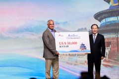 Yu SONG (right), Director General of Beijing Bureau of Culture and Tourism, gives an award to Paul COHEN, managing director of International Experiences of the US.