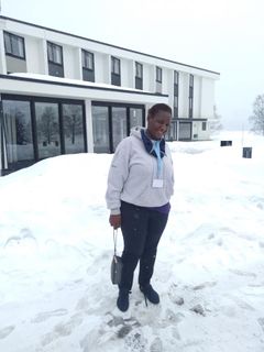 Julia Mwashi (41) utanfor Hurdalsjøen hotell, der ho denne veka deltok på eit nettverksmøte for Norec-partnarar. Foto: Robina Asiimwe Sentumbwe. Til fri bruk.