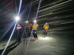 Frivillige fra Norsk Folkehjelp Tromsø under en redningsaksjon natt til lørdag. To personer satt værfaste i ei nødbu på fjellet Kjølen på Kvaløya og trengte hjelp til å komme seg ned igjen.