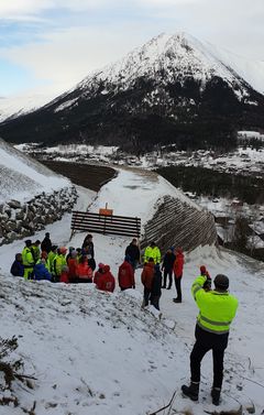 Fra synfaringa. Sikringsvollen sikrar mot steinsprang og skred. Foto: NVE
