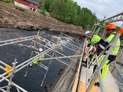 STS Stillas monterer hengestillaset som skal brukes i arbeidet med å forsterke dammen. Prosjektleder Tor Åmdal følger med.