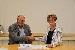 Steinar Myhre, konserndirektør Skanska, og Berit Brendskag Lied, regionvegsjef SVV under signeringen av fylkesvei 17. Foto: Nina Kjeøy