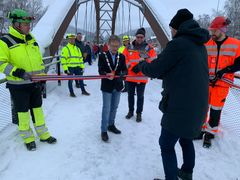 Ordfører i Ringebu Arne Fossmo åpnet Våla gang- og sykkelbru. Odd Inge Aaheim, Anlegg Øst (t.v.) og Henrik Eineteig Wedum, Statens vegvesen holdt i hver sin ende av snora. Bak ordføreren Jan Nørstegård, Statens vegvesen. (Foto: Eli Ramstad, Statens vegvesen)