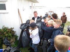 Elever fra Slevik skole viser stolt frem hva de fant på strandryddeaksjonen til miljøvernministeren