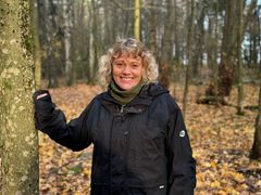 Forsker Aina Winsvold i svart jakke i skogen