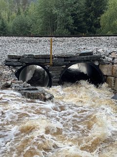 Store vannmengde renner gjennom to store rør under jernbanen.