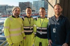 Portrettbilde av 4 menn i gule arbeidsklær