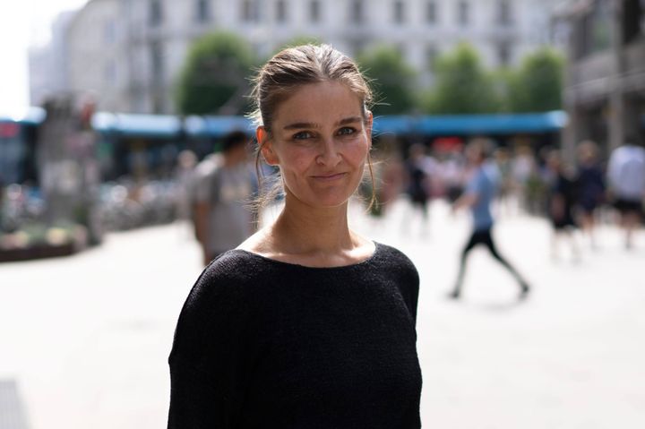 Portrett av Eli Marie Stavlund i Av-og-til. Hun står utendørs i solskinnet med byen i bakgrunnen.