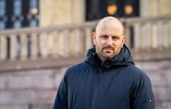 Bernt Lind-Aaby i halvfigur med Stortinget i bakgrunnen.