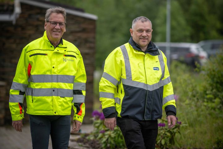 To%20menn%20i%20gule%20arbeidsjakker%20st%E5ende%20utend%F8rs%2C%20omringet%20av%20gr%F8nn%20vegetasjon.