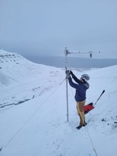 Eirik Albrechtsen på jobb for Arctic Safety Centre med Longyearbyen i bakgrunnen.