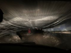 En mørk tunnel med lav takhøyde på veg ned i gruva