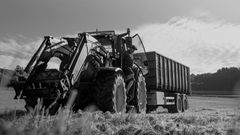 En gårdbruker på veg ut av en traktor på et jorde