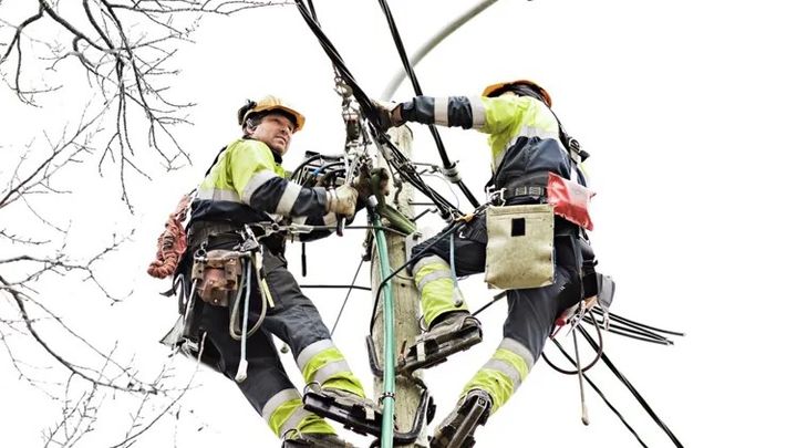 To arbeidere jobber i en høyespentmast
