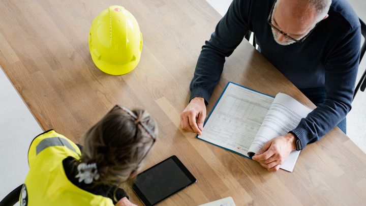 Bildet viser to personer som går gjennom en sjekkliste på tilsyn.