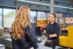 Butikkansatt håndterer kunde i kassen i en matvarbutikk.