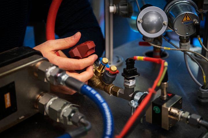 Bilde fra maskiningeniørutdanningen på OsloMet som viser en hånd som tar i utstyr på et laboratorium.