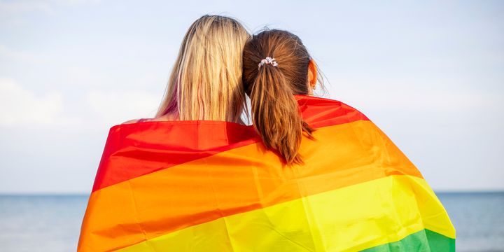 Bilde av to jenter med regnbueflagget rundt seg.