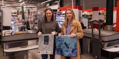 To unge kvinner i butikk holder handlenett og plastpose