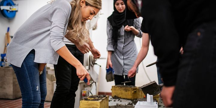 En gruppe byggingeniørstudenter jobber jobber med betong.