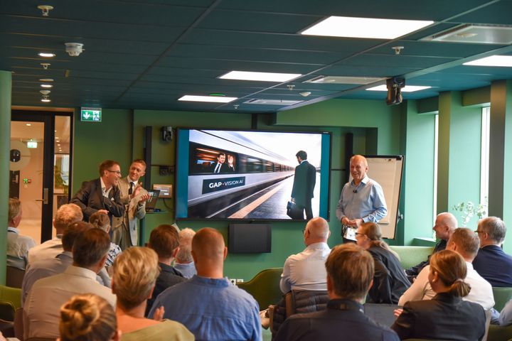 A group of people attending a presentation about GapVision AI in a modern conference room.