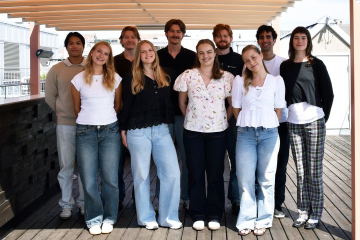 ti unge personer står i to rader under en pergola