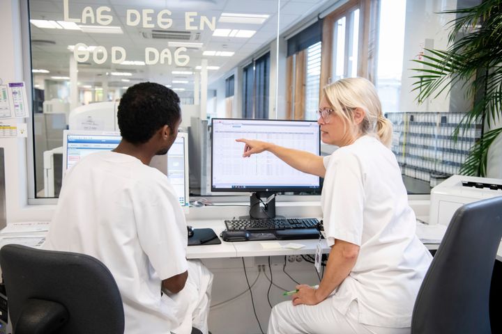 Sykepleier viser kollega noe på skjerm