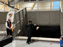 Ordfører i Voss herad Tonje Såkvitne kaster første pose med matavfall inn i mottakslommen i biogassanlegget.