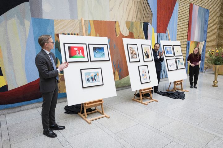 Leder Tage Pettersen i Stortingets kunstutvalg, stortingspresident Masud Gharahkhani og medlem Agnes Nærland Viljugrein i Stortingets kunstutvalg klapper etter å ha avduket 10 avistegninger.