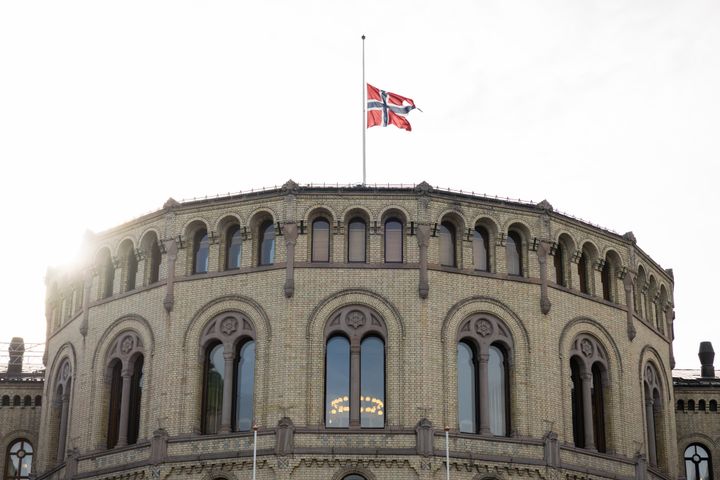 På toppen av stortingsbygningen vaier flagget på halv stang.
