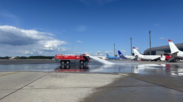 Brannbilene er klare for å vanne asfalten på Oslo lufthavn. (Foto: Avinor)
