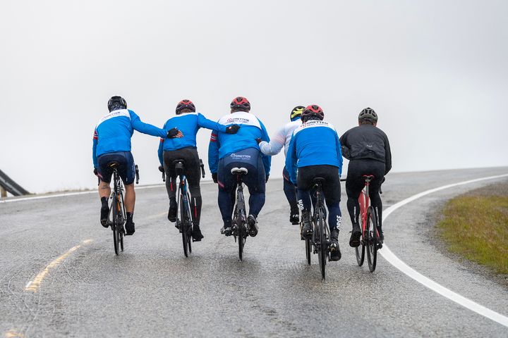ETT LAG: Arctic Race of Norway bruker ofte dette bildet av deltakerne fra Idretten skaper sjanser som hjelper en lagkamerat opp bakken til Nordkapp, for å beskrive hvor viktig samarbeid er.