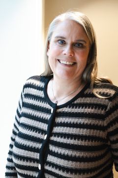 Kvinne som smiler i stripete jakke og er direktør av ykre