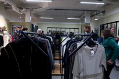 Bilde av interiøret i Fretex-butikken på Strømmen Storsenter, med klesstativer fulle av klær og folk som handler.