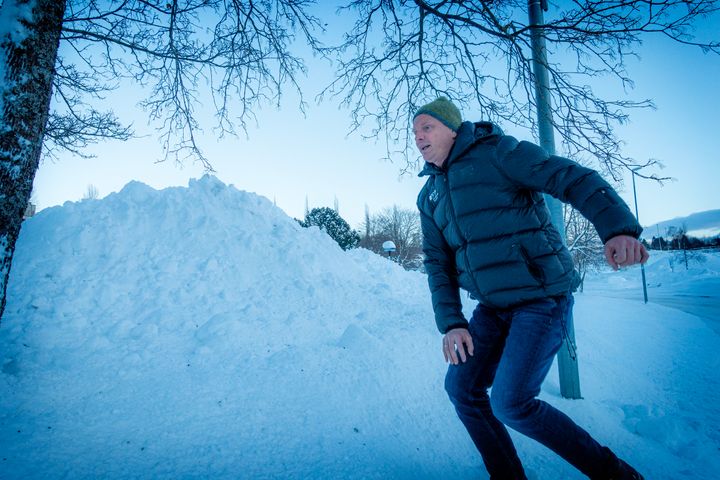 Mann som klatrer opp i en snøhaug, kulde