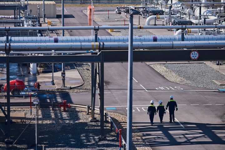 three employees waling on a gas receiving terminal