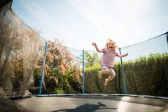 Barn som hopper på trampoline i sommerværet.