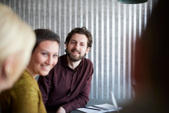 Ansatte i samtale rundt et bord i møterom