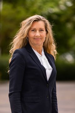 Portrettbilde av kvinne i svart blazer og hvit skjorte.