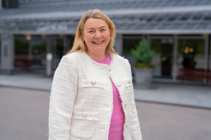Smilende kvinne i hvit jakke