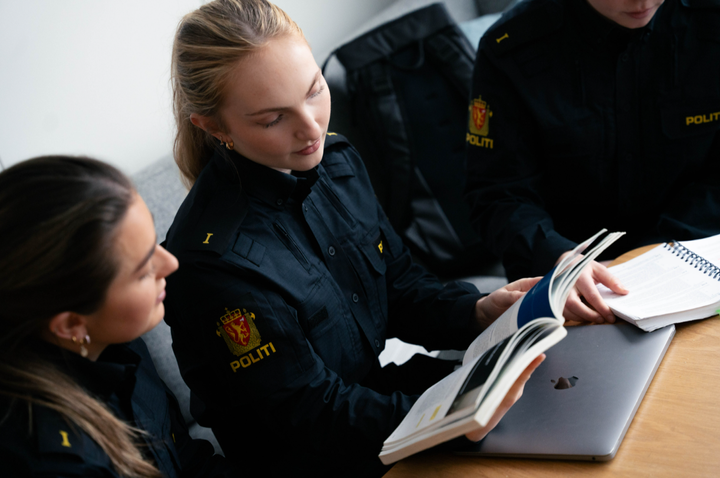 Bilde av politistudenter som leser pensum