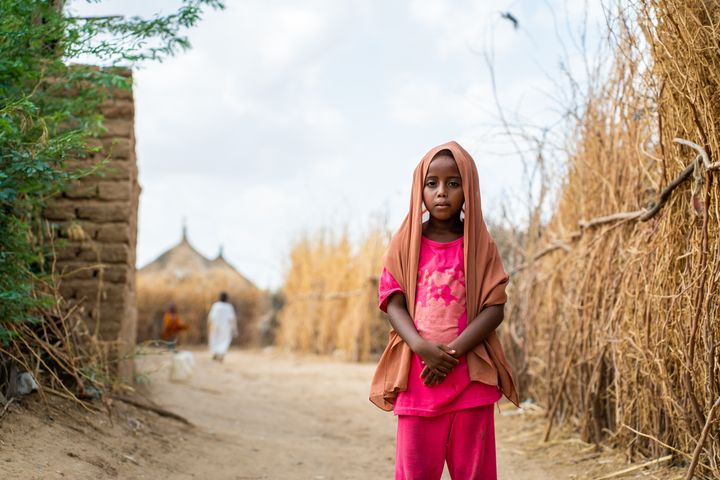 En jente foran en av flyktningleirene i Sudan, 2025.